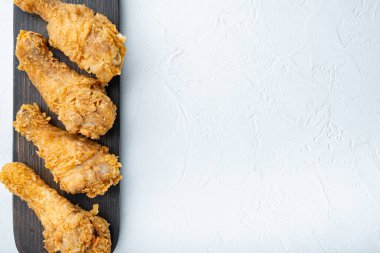 Beyaz arka planda, düz bir zeminde, metin için yeri olan Kentucky usulü tavuk bateri parçaları..