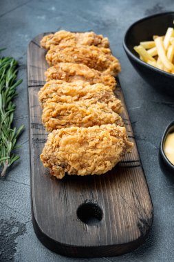 Baharatlı, yağda kızartılmış tavuk kanadı. Gri arka planda kesilmiş..