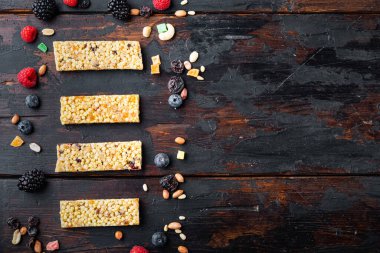 Tohumları ve fındıkları olan çiğ organik granola bar, fotokopi alanı ve ahşap masa üzerinde üst görünüm.