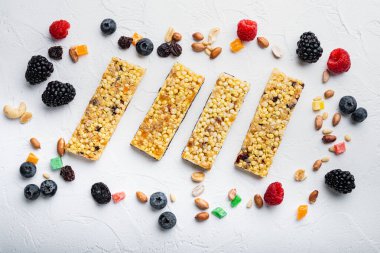 Granola çubuğu ve malzemelerin karışımı, düz yatış, beyaz arkaplan