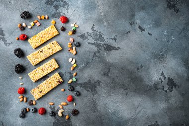 Yulaf ezmeli ve taze böğürtlenli süper yiyecek kahvaltı barları, fotokopi alanı olan üst manzara, gri arka plan.