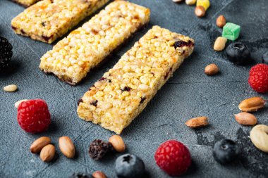 Gri arka planda karışık fındıklı, tohumlu ve meyveli ev yapımı granola barlar.