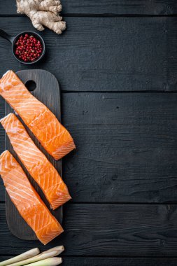 Somon otları ve baharatlarla dolu balık kekleri siyah ahşap masa üzerinde, üst görünümü metin için alan