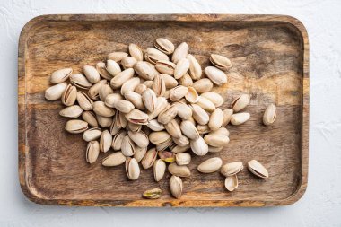 Kabuklu, tuzsuz şam fıstığı, beyaz desenli arka plan, düz uzanış