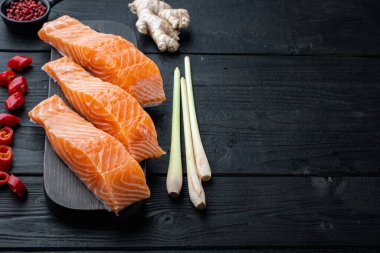 Pirzola için çiğ somon eti, siyah ahşap masa üzerinde metin için yer var.