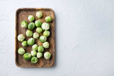 Beyaz desenli arka planda ham Brüksel lahanası, metin için boşluk ile düz yatar