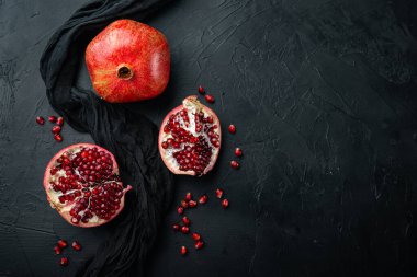 Sulu çekirdekli olgun nar, siyah desenli arkaplan, düz metin alanı