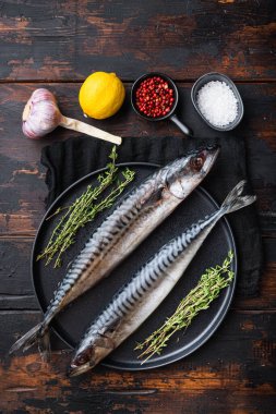 Çiğ uskumru, ahşap masanın üzerinde malzemeler var..