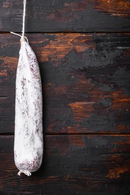 Esmer ahşap zemin üzerinde geleneksel İspanyol kuru longaniza sosisi kopyalama alanı ile.