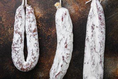 Kurutulmuş sucuk ve sosis eski metall arka planda asılı..