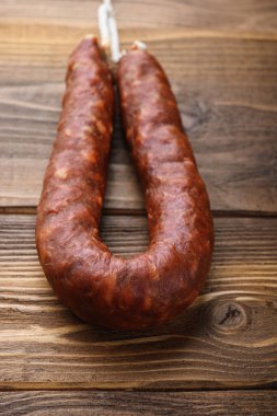 Hafif ahşap arka planda baharatlı sucuklu sucuk..