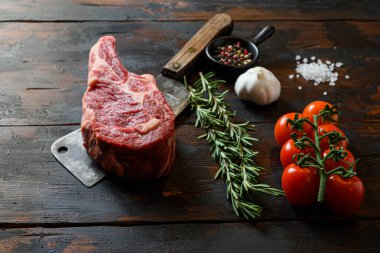Et satırında çiğ Dallas bifteği. Organik çiftlik mermer kaplama siyah angus bifteği. Koyu ahşap arka plan. Yan görüş. Baharat, biber, biberiye, tuz, sarımsak. Kimse yaklaşmasın.