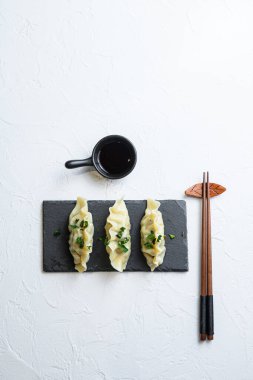 Kimchi köfteleri Çin yemeği siyah taş tabakta etli hamur köfteleri beyaz desenli arka plan görüş alanı üzerinde hiç kimseye mesaj yok.