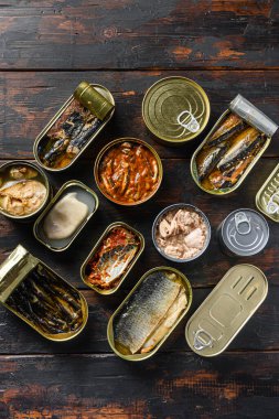 Farklı balık ve deniz ürünleri içeren konserve kutuları kırsal ahşap kalasların üzerinde. .