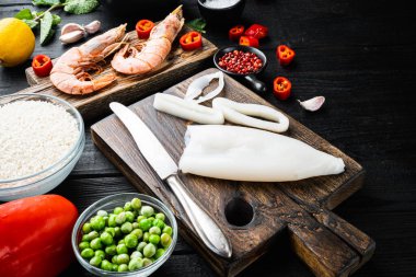 Geleneksel İspanyol paella spesiyaliteleri için siyah ahşap masa üzerinde deniz ürünleri, yemek fotoğrafı..