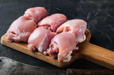 Et satırlı taze tavuk butları, siyah arka planda, metin için üst görünümü olan..