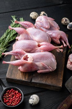 Siyah ahşap arka planda taze çiğ bıldırcın.