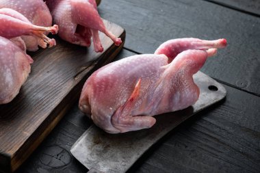 Çiğ bıldırcın seti, siyah ahşap arka planda.