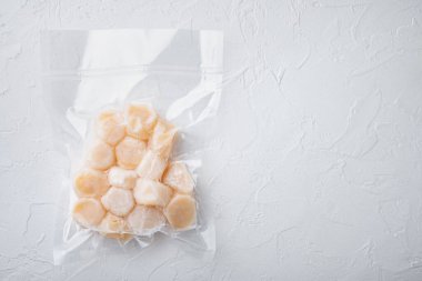 Vakum paketinde donmuş et istiridyeleri, düz bir zemin, beyaz desenli arkaplan ve metin için boşluk