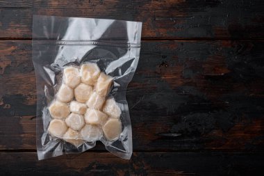Scallops, vakum paketi, üst görünüm, kopya alanı ile koyu ahşap arkaplan