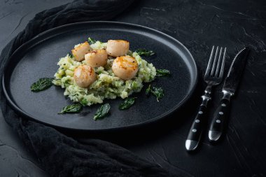 Izgara deniz tarağı ve patates püresi, siyah desenli arka plan.