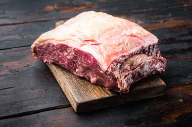 Striploin bifteği, çiğ et kasabı. Eski ahşap masada kesilmiş.