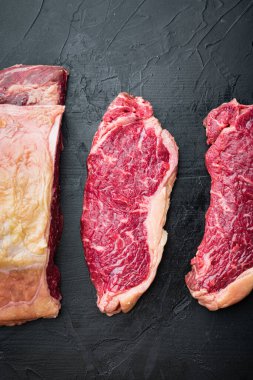 New York bifteği çiğ et, siyah arka planda, üst manzara.
