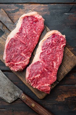 Strip biftek, mermer et, eski ahşap masa, üst manzara.