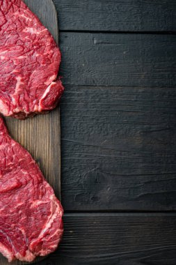 En iyi sığır eti bifteği, siyah ahşap masa üzerinde, üst manzara, metin için kopya alanı ile.