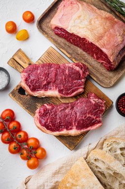 Çiğ biftekli burger malzemeleri, mermer etli, beyaz arka planda, üst manzara.