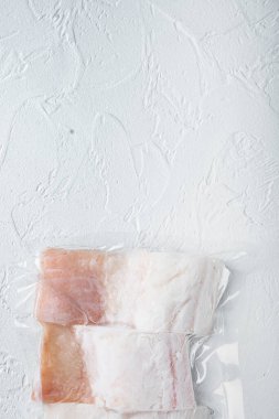 Beyaz mezgit balığı filetosu plastik pazar paketinde, beyaz arkaplanda, metin için metin alanı ile üst görünüm