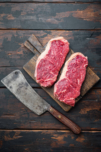 Veiny steak, marbled beef raw meat, on dark wooden background, top view