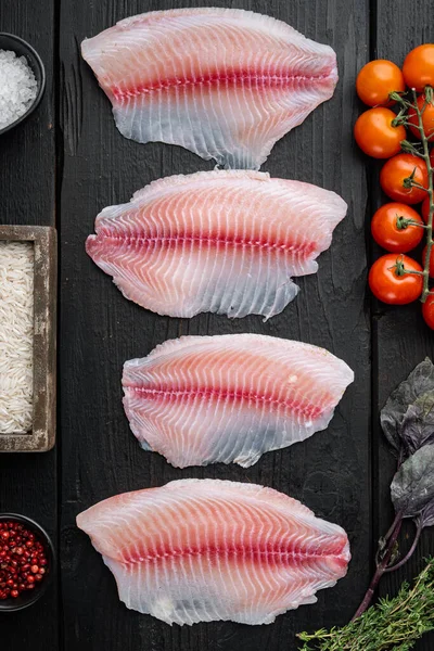 生の白身魚ティラピア バスマティライスとチェリートマトの成分 黒木製の背景に トップビュー — ストック写真