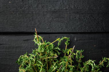 Kekik yeşil demet, siyah ahşap masa üzerinde, metin için kopya alanı ile üst görünüm