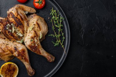 Siyah zemin üzerine serpilmiş tavuk ve otlar, metin için kopya alanı ile üst görünüm