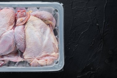 Plastik vakum tepsisinde çiğ tavuk seti, siyah arkaplan, metin için kopya alanı ile üst görünüm