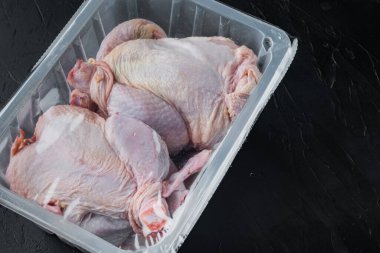 Plastik kapaklı plastik kutuda çiğ tavuk, metin için kopyalama alanı ile siyah arkaplan