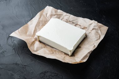 Çiğ organik beyaz peynir seti, siyah arkaplanda.