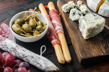 İspanyol yemeği, et çerezi, seti, koyu ahşap arka planda bulunan otlar.