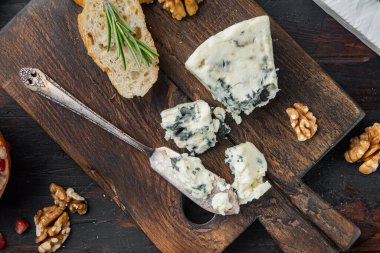 Bir dilim Danimarka peyniri, koyu ahşap arka planda, düz uzanmış