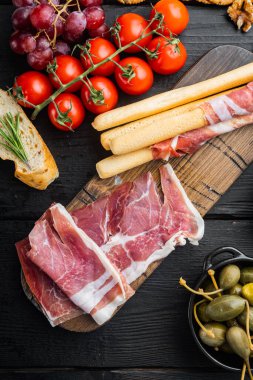Prosciutto dilimleri, siyah ahşap masa, üst manzara.