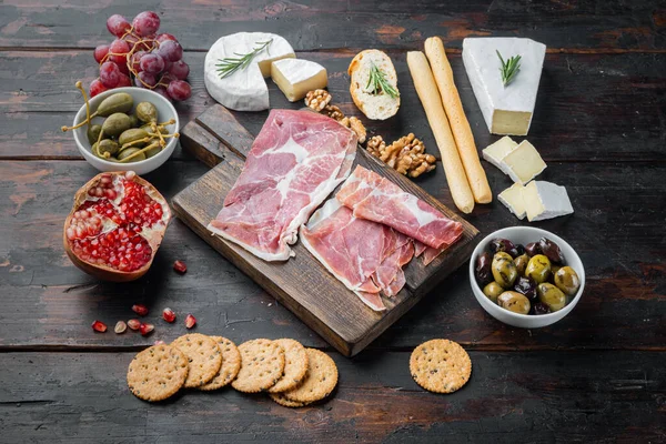 Appetizers table with differents antipasti set, on dark wooden background