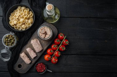 Makarna ve sebze malzemeli ton balığı salatası, siyah ahşap masa üzerinde, metin için fotokopi alanı ile düz yatıyordu.