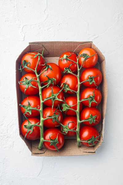 Ripe cherry tomatoes in box, on white background, top view