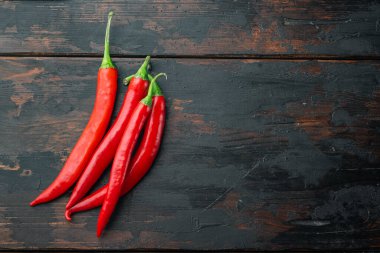 Tüm kırmızı biber seti, eski ahşap masa üzerinde, üst görünüm veya düz metin için kopyalama alanı ile yatıyordu