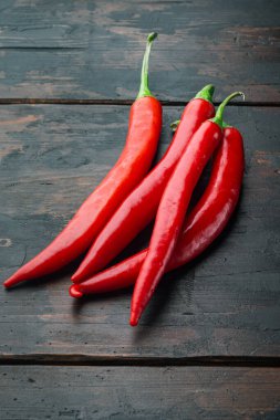 Olgun kırmızı biber seti, eski ahşap masada.