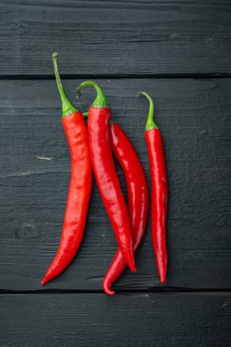 Tam kırmızı biber seti, siyah ahşap arka plan, üst ya da düz yatıyordu