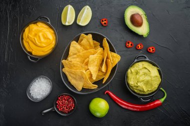 Nachos mısır cipsi geleneksel sos seti, siyah arkaplan, üst görünüm veya düz yatıyordu