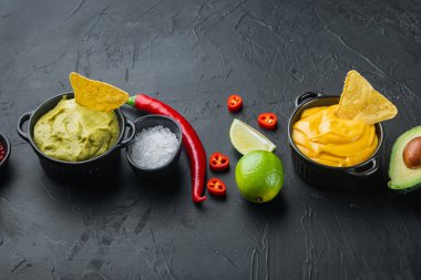 Geleneksel Meksika tacoları için yeşil guacamole ve sarı peynirli sos, metin için fotokopi alanı ile siyah arkaplan