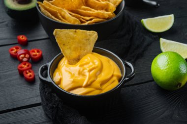 Siyah ahşap arka planda peynir soslu kase.